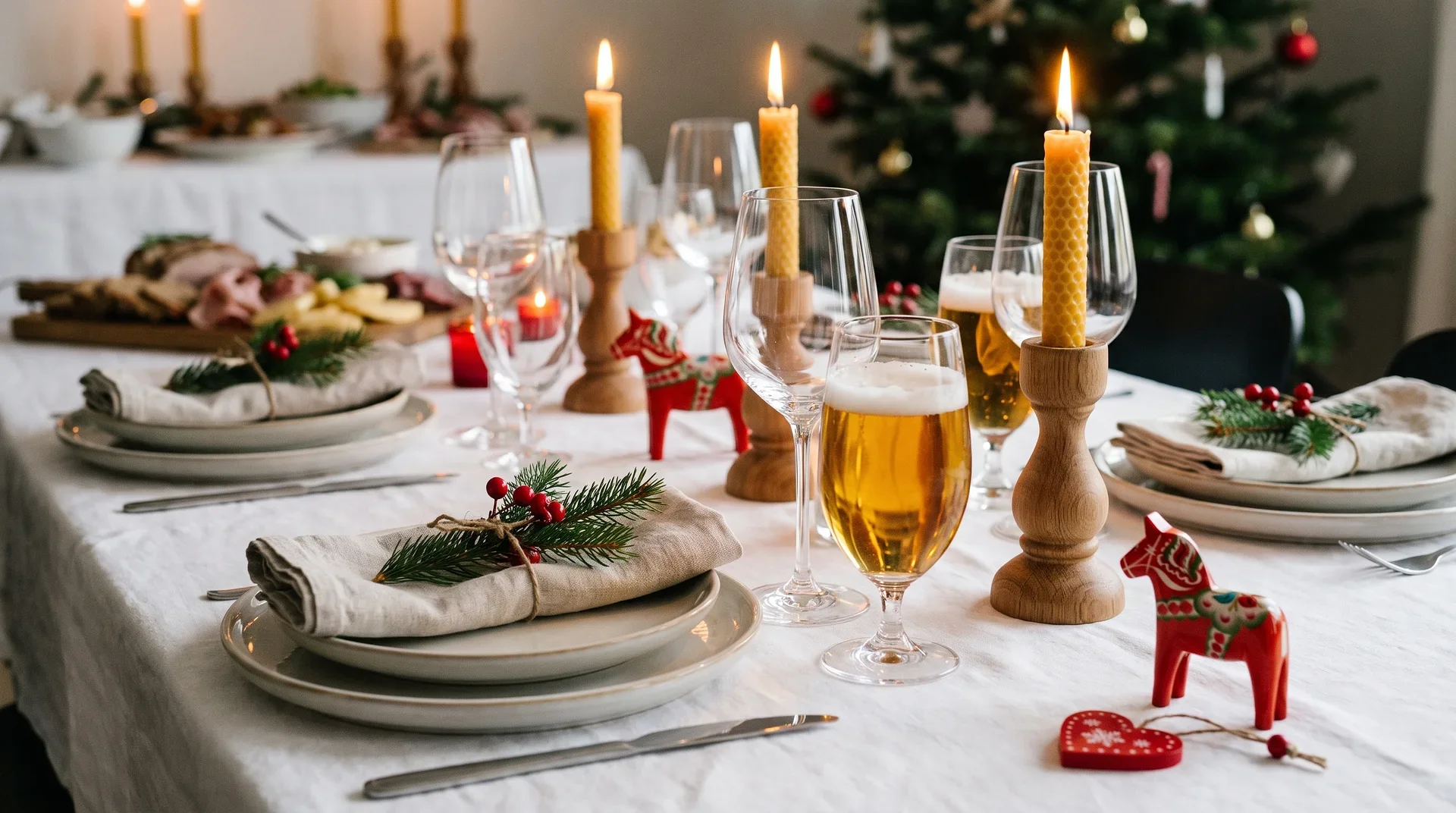 Juldukat bord med tallrikar, glas, ljuslyktor och röda dekorationer